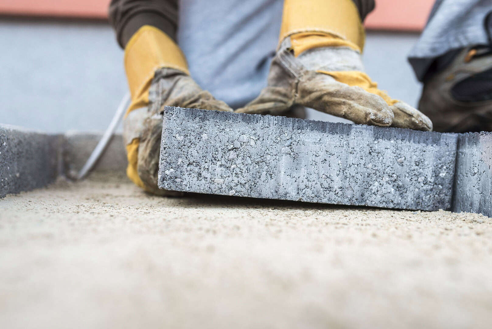 Building contractor laying a paving slab